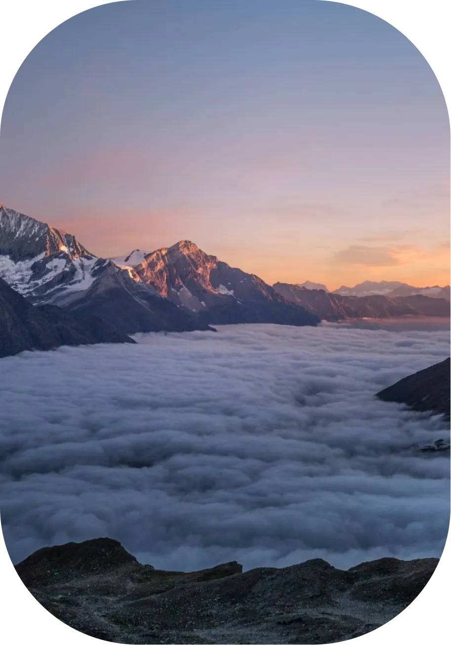 山の頂上が夕日に照らされてるアルプス山脈やヒマラヤ山脈などの雲海の様子